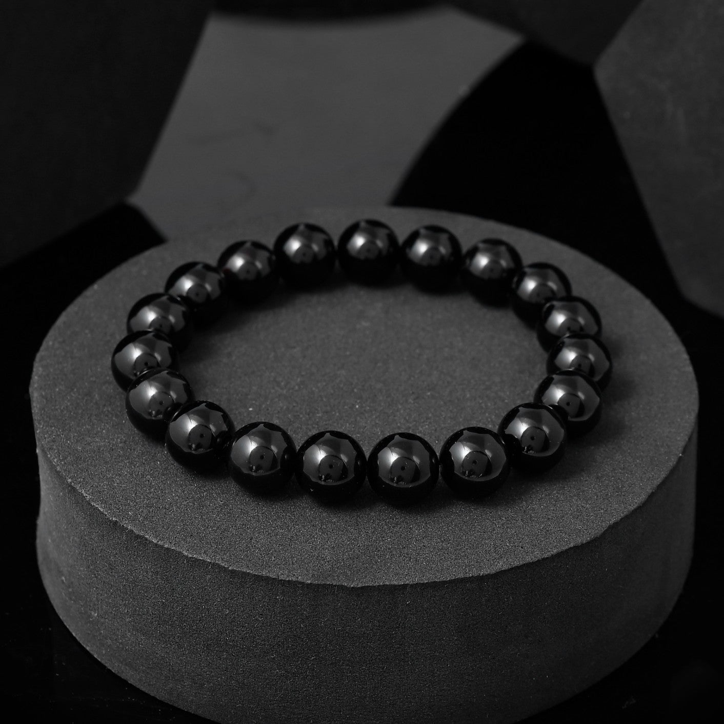 Close-up of a black beaded bracelet . The image shows the bracelet's round, black beads strung together on a flexible cord