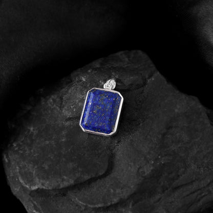 Rectangular lapis stone with a captivating blue hue, accented by silver inclusions, adorns a unique pure silver pendant.