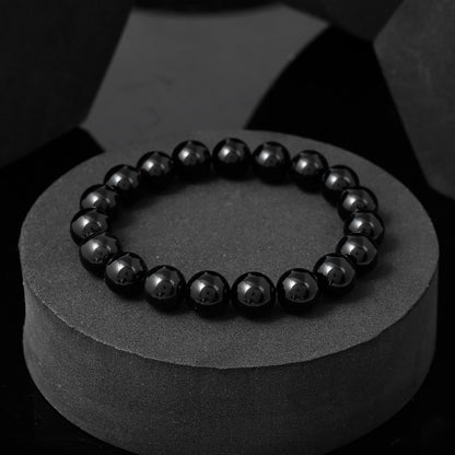 Close-up of a black beaded bracelet . The image shows the bracelet's round, black beads strung together on a flexible cord