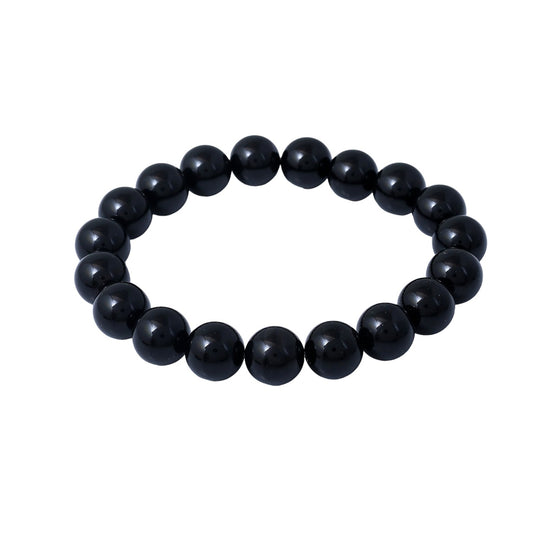 A simple black bead bracelet rests on a clean white background. The smooth, round beads are evenly spaced along the stretchy cord.