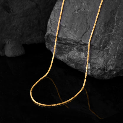 Close-up of a gold box chain necklace for men.  The timeless design makes it a versatile neck accessory for men or boy