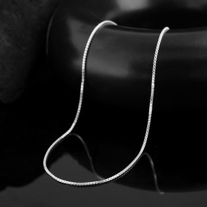 A close-up photo of a pure silver neck chain for men,  A perfect gift for the man who appreciates understated elegance.