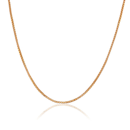 A gold box chain necklace for men with a curb link design, reflecting light on a white background. 