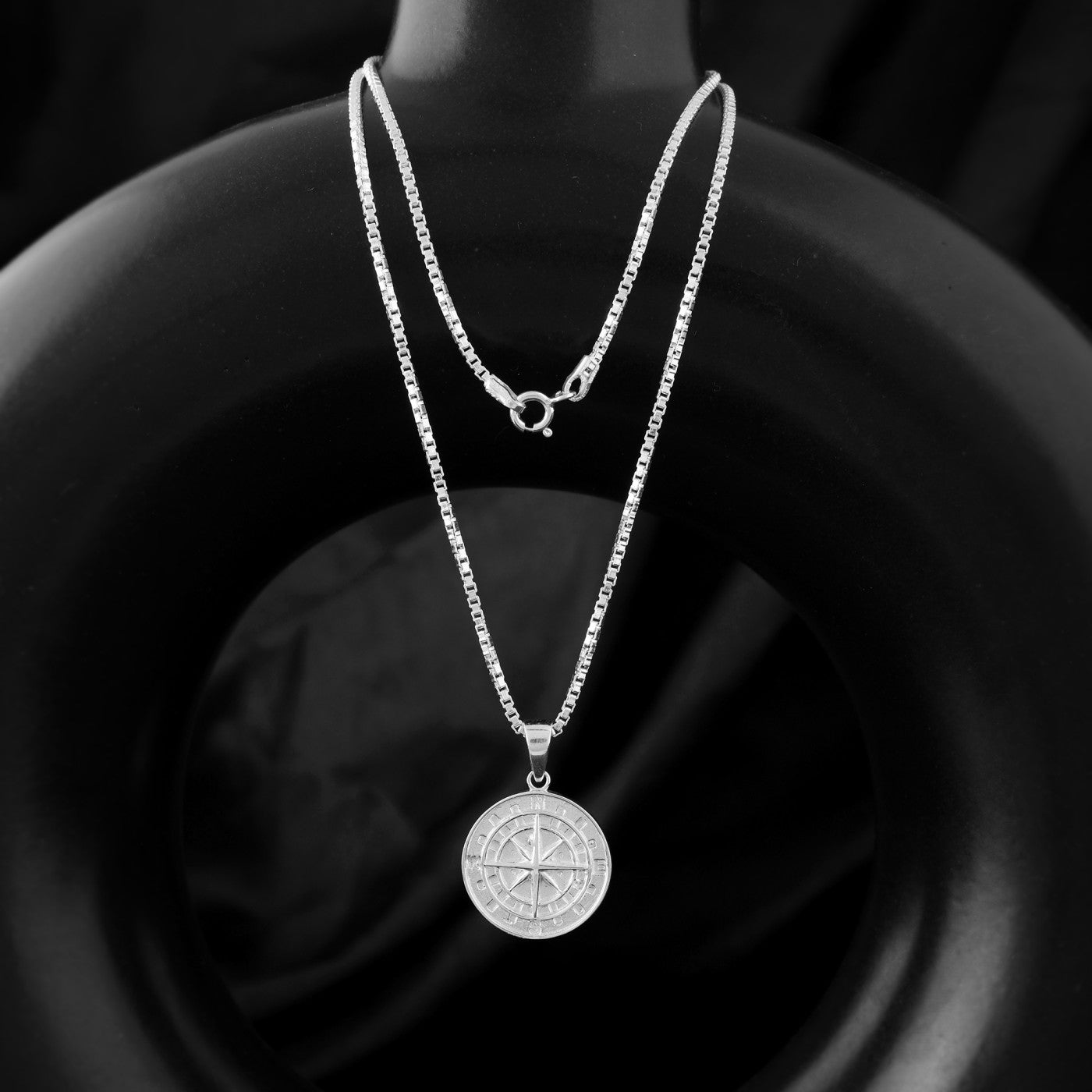 a 925 sterling silver necklace with a compass charm. Compass jewelry is often worn as a reminder to stay on course and pursue your goals.