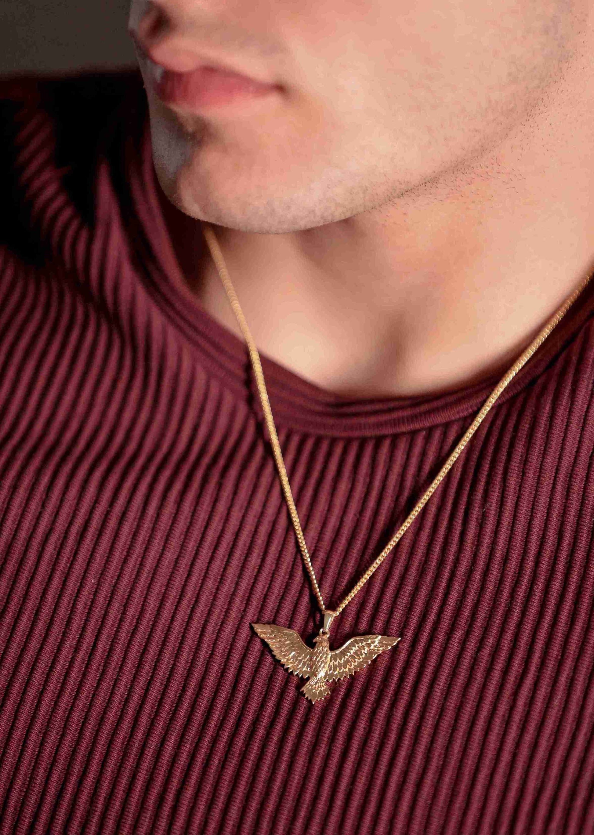 a gold eagle bird pendant for men captures the freedom of flight with its outstretched wings hangs on a gold chain