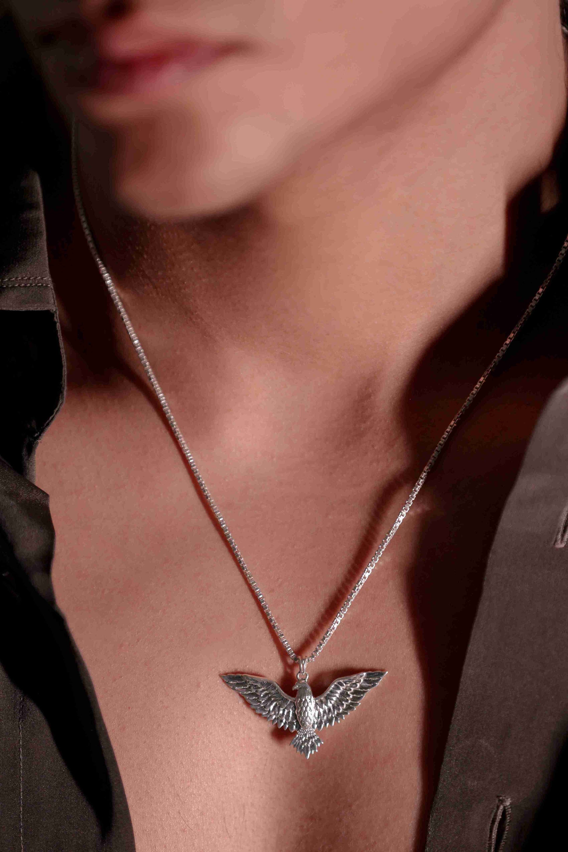  a 925 sterling silver bird pendant for boys  in mid-flight, its wings extended for balance.