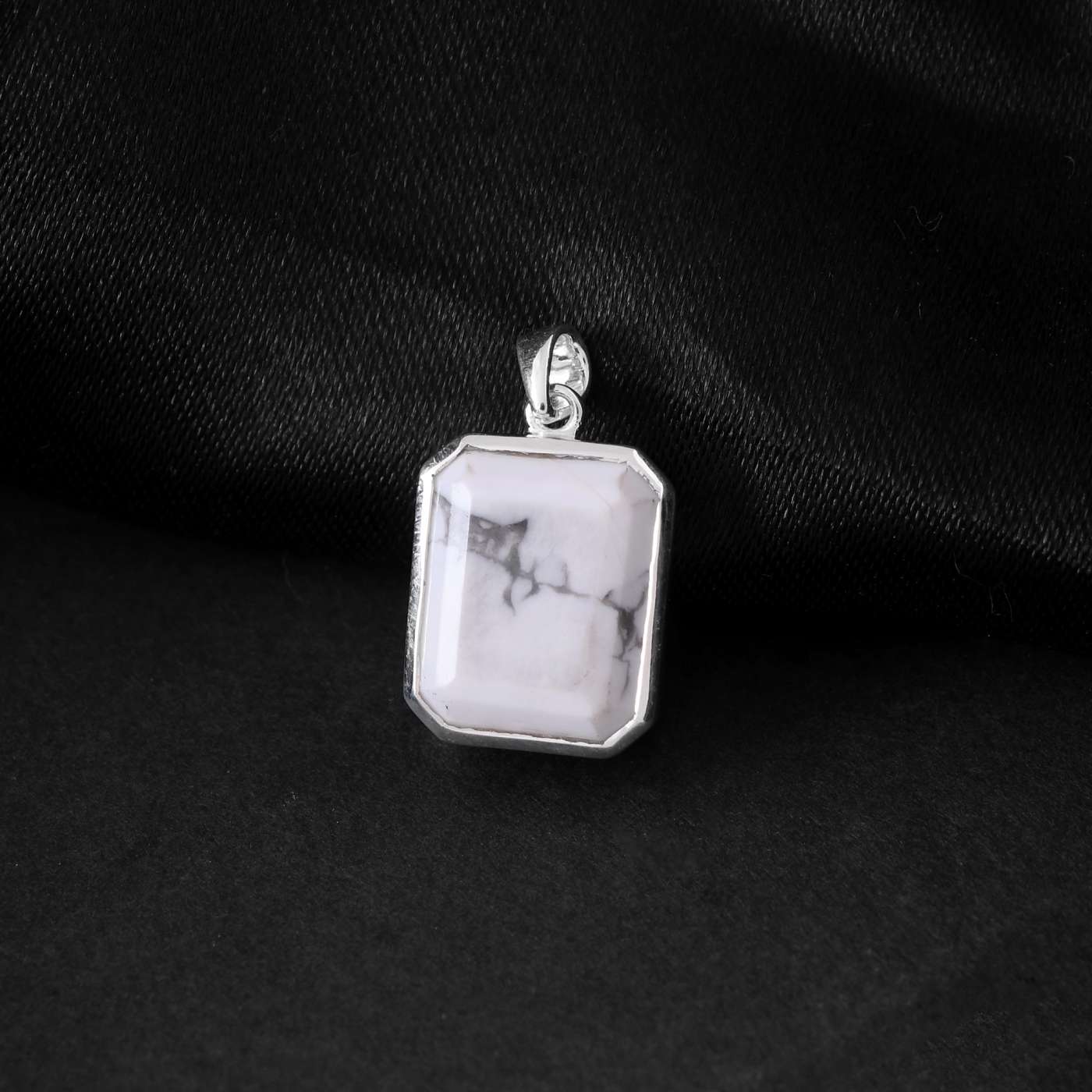 A luminous howlite white stone mens locket takes center stage in this striking silver jewellery for men. 