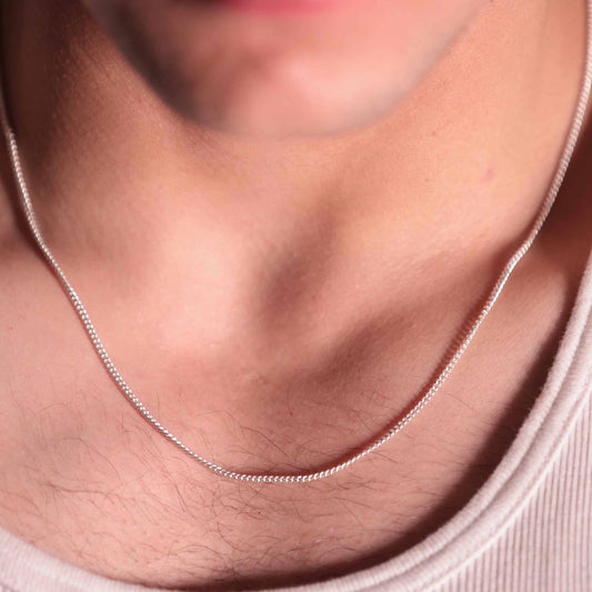 Close-up view of a pure silver chain necklace for boy. The intricate links shimmer.