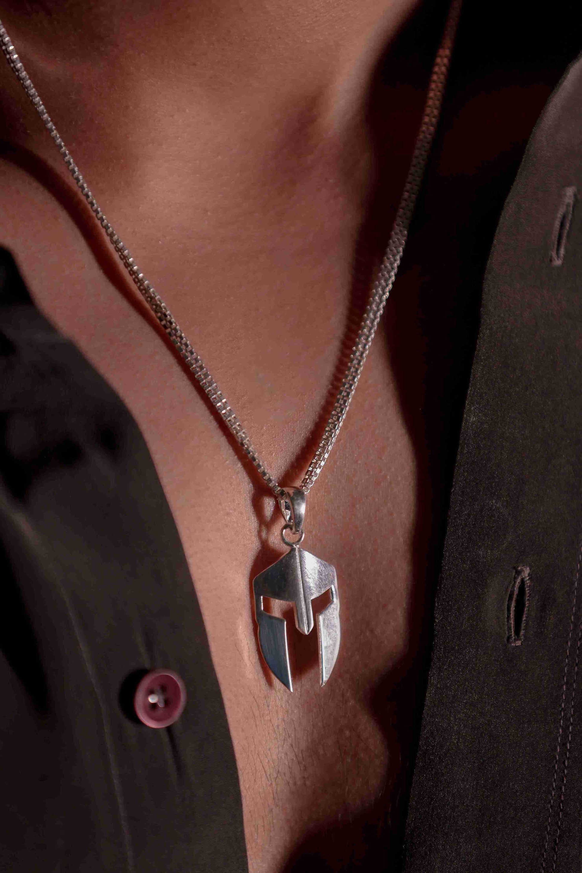 Representing the warriors of ancient Greece, a small Spartan helmet pendant crafted in silver hangs from pure silver chain for men.