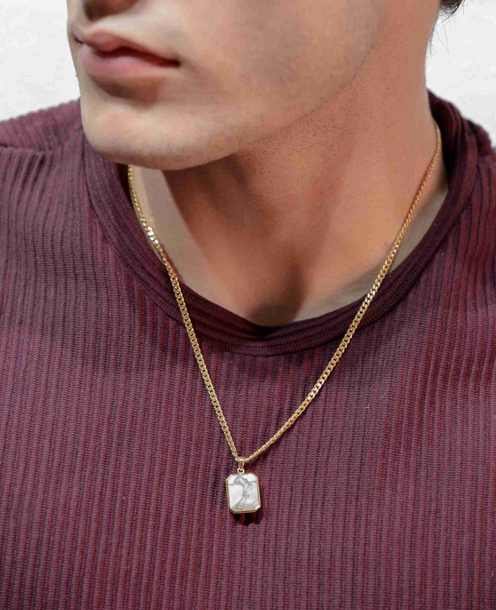 This unique gold pendant showcases a single howlite stone hangs from a latest gold chain design for men.