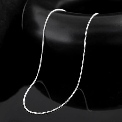 A sterling Silver link chain necklace for men photographed in detail. The interlocking links create a sense of movement 