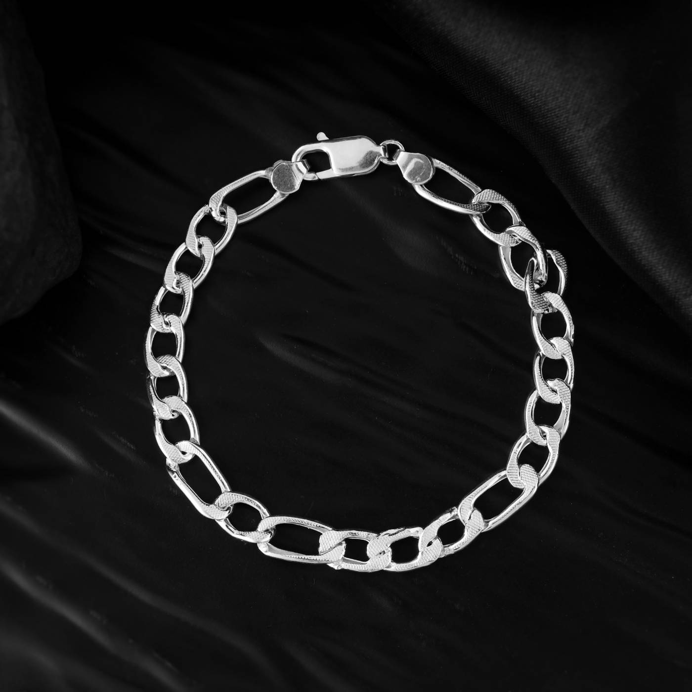 A close-up view of a pure silver bracelet for men with a reflective surface. A perfect gift for the man who appreciates understated elegance.