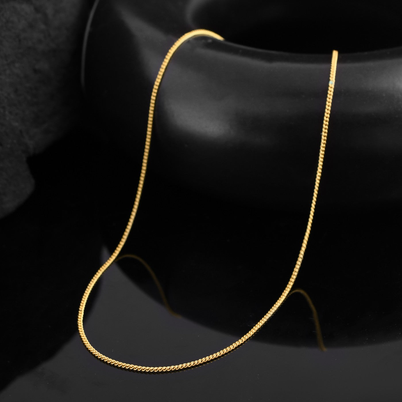 Gold link chain necklace for men in a close-up view. The polished links catch the light, creating a dynamic pattern 