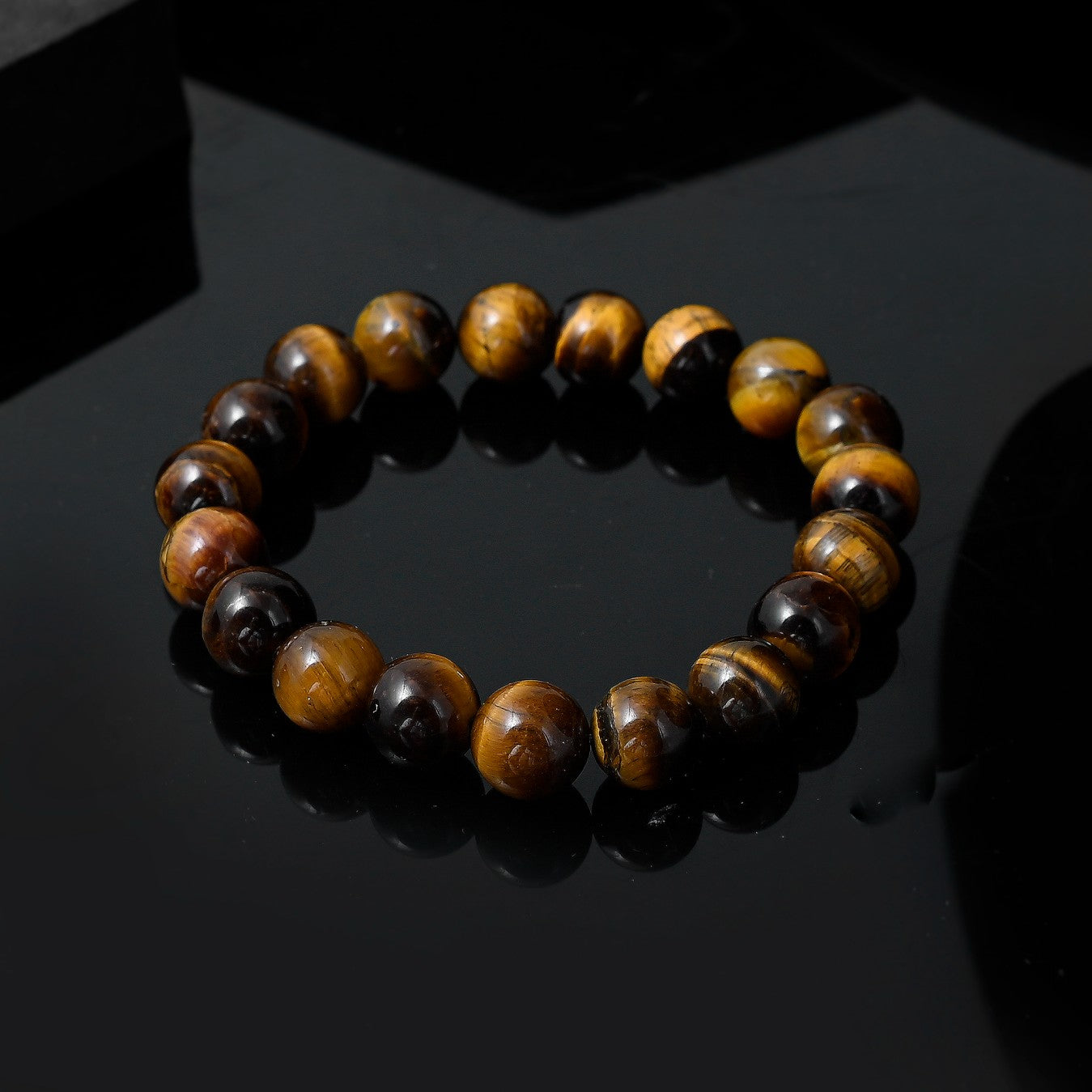 Close-up of a tiger's eye hand bracelet for men. Polished gemstone beads in shades of brown, gold, and black showcase a mesmerizing chatoyant effect.