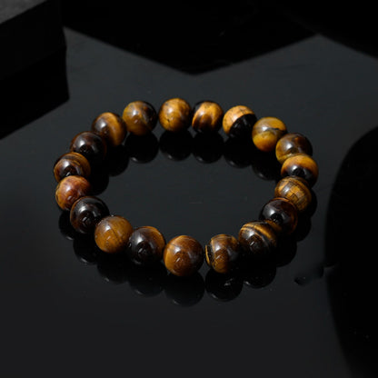 Close-up of a tiger's eye hand bracelet for men. Polished gemstone beads in shades of brown, gold, and black showcase a mesmerizing chatoyant effect.