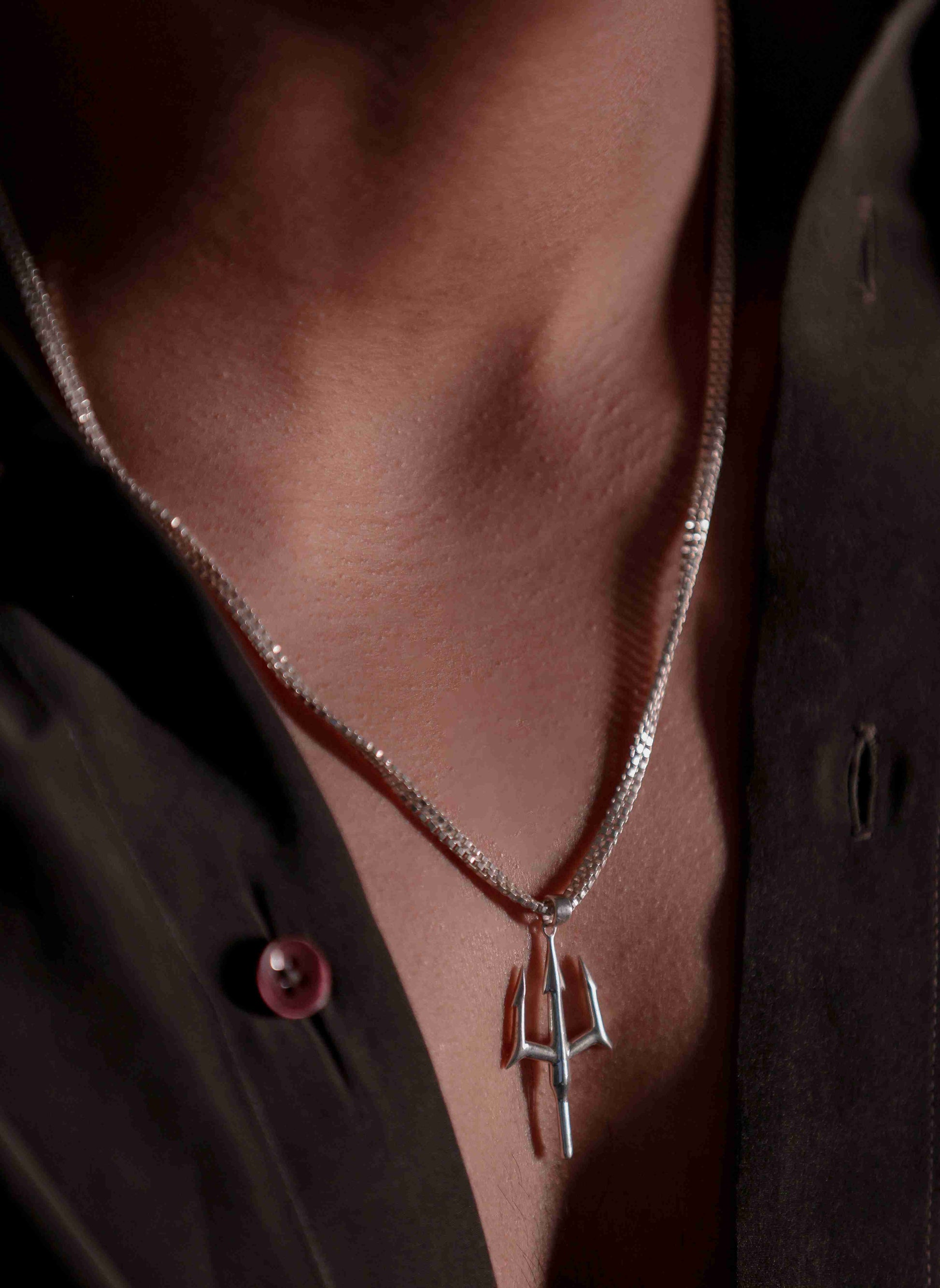 Channeling the power of the ocean, a sterling silver trident pendant hangs from a thin chain. Tridents can represent Poseidon, the Greek god of the sea.