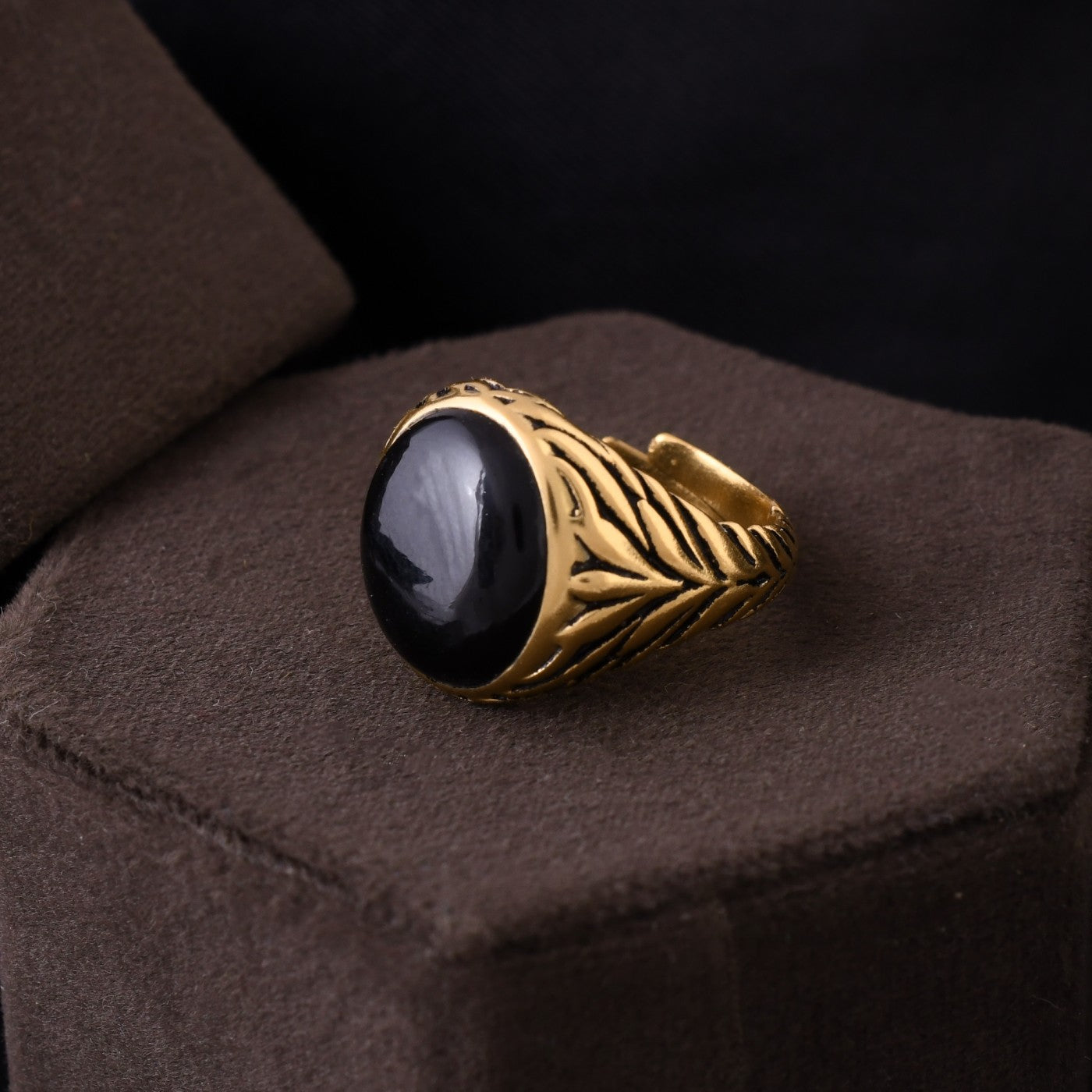 Black magic in gold: this stylish men's ring features a captivating black stone set in a gleaming gold band. 